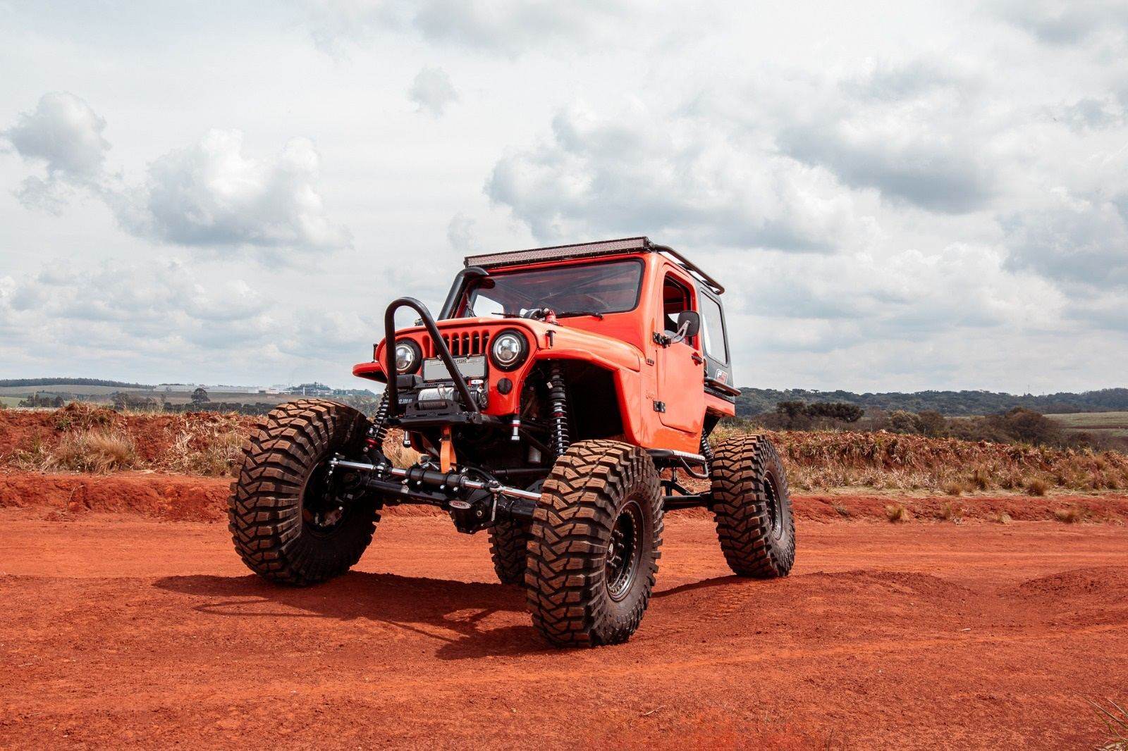Jeep laranja com coilovers PS Amortecedores em estrada de terra