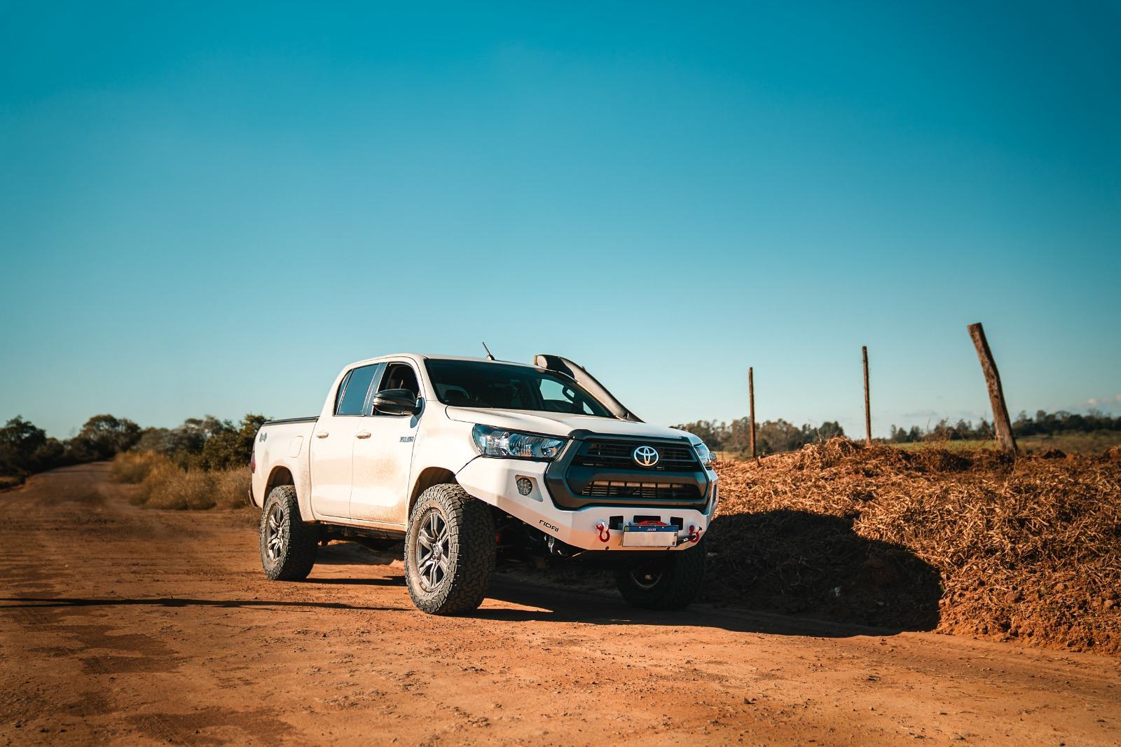 Toyota Hilux preparada para overlanding em estrada de terra com suspensão PS